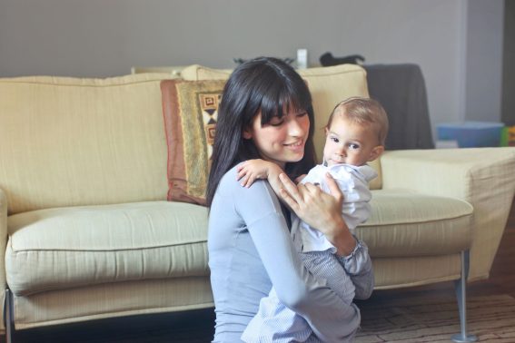 Mère tenant son bébé dans les bras sur un canapé